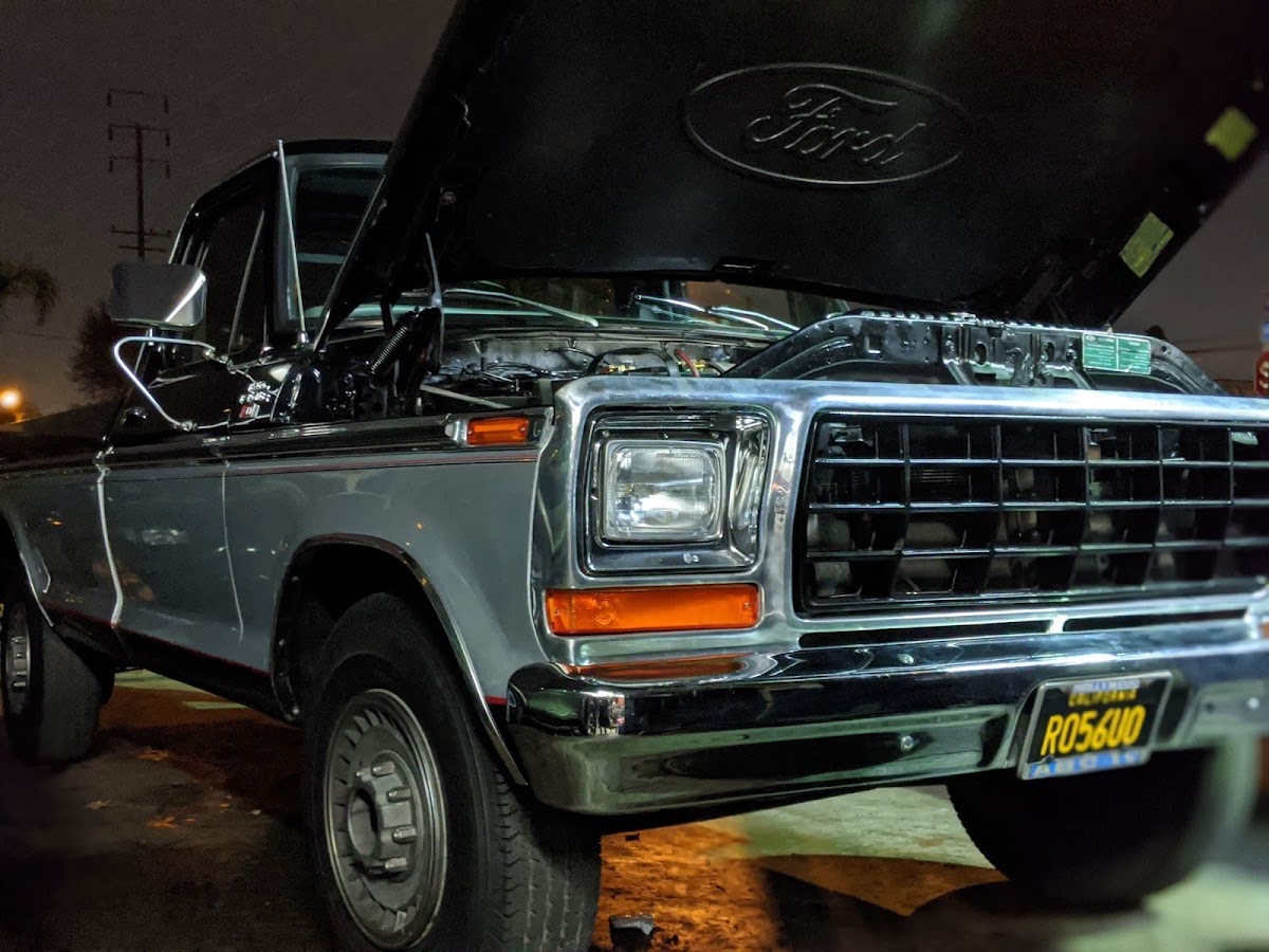 1970s Ford F-series pickup in for work at night with the hood up