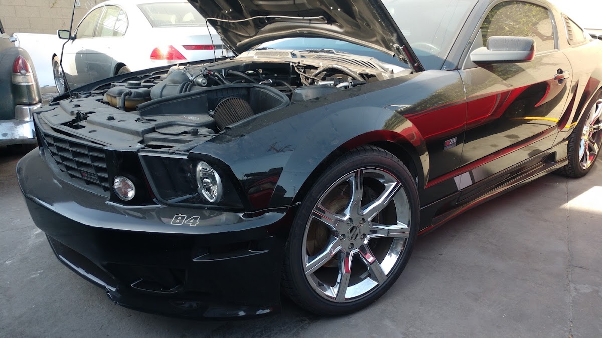Black Saleen Mustang with the hood up in the bay at J and J Auto Repair